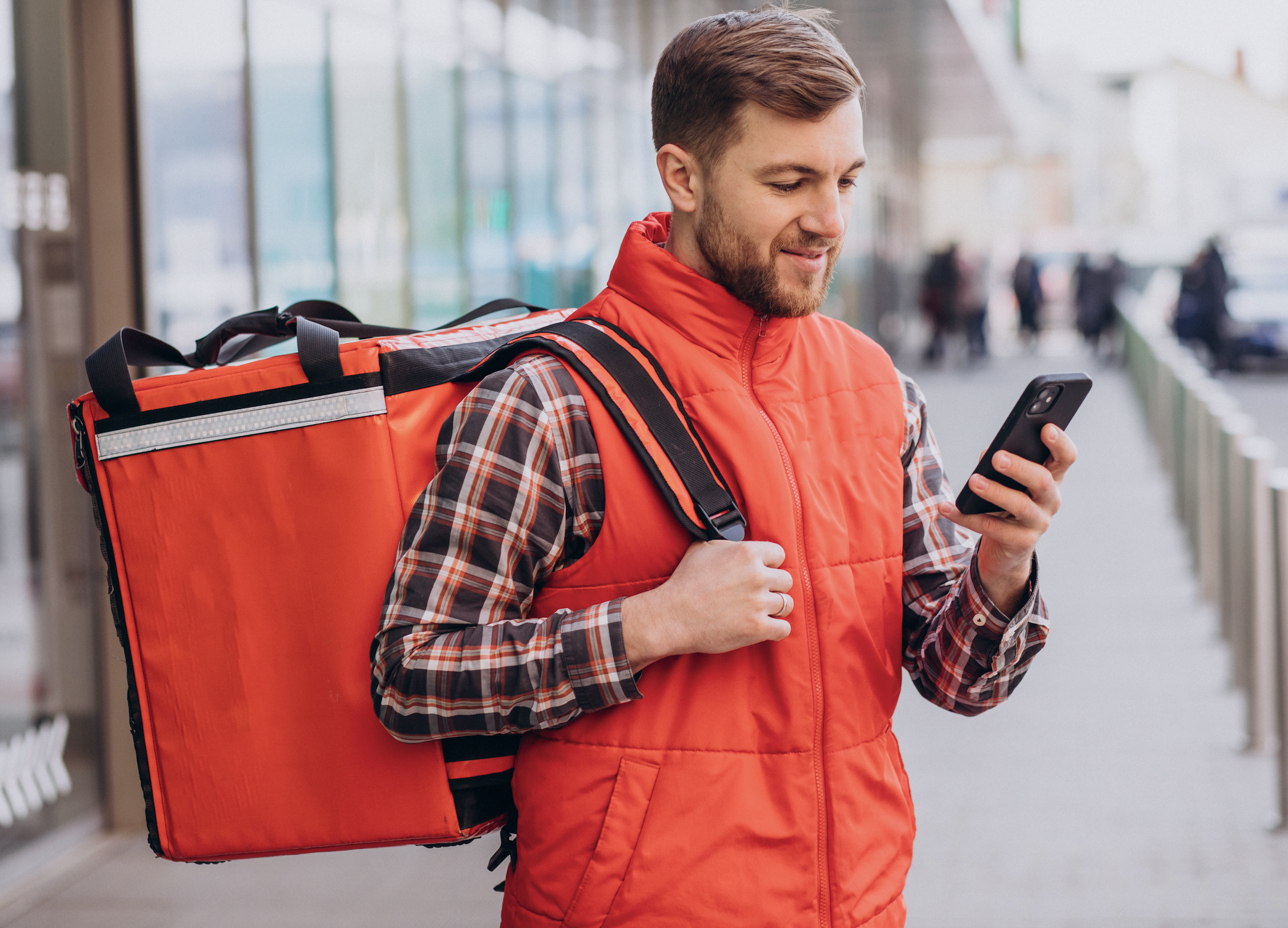 delivery driver looking into his phone and smiling